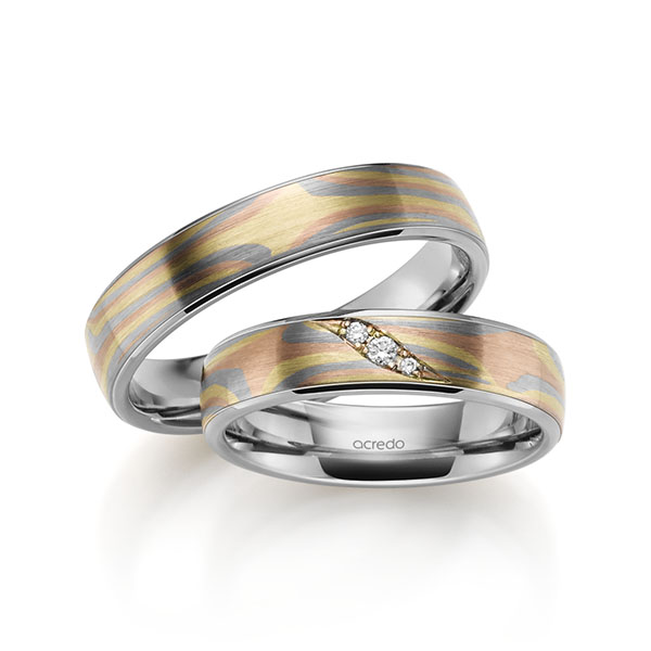 Set Bicolor trouwringen in Mokume Gane groengoud, roodgoud 14 kt., grijsgoud 14 kt. Basis-Ring grijsgoud 14 kt. met in totaal 0,035 ct. Briljant tw,vs van acredo