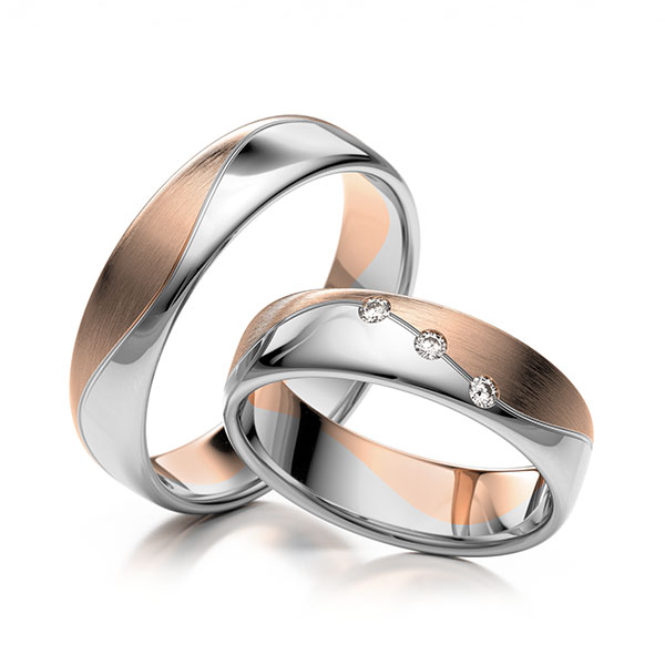 Set Bicolor trouwringen in wit 9 kt. goudhoudend metaal (37,5%) rood 9 kt. goudhoudend metaal (37,5%) met in totaal 0,06 ct. Briljant tw,vs 